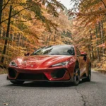 Voiture de sport rouge garée sur une route sinueuse des Ardennes belges en automne